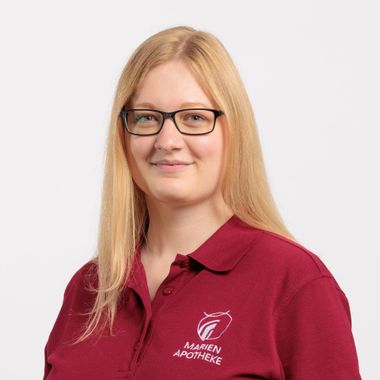 Eine Frau mit Brille und rotem Hemd lächelt in die Kamera.