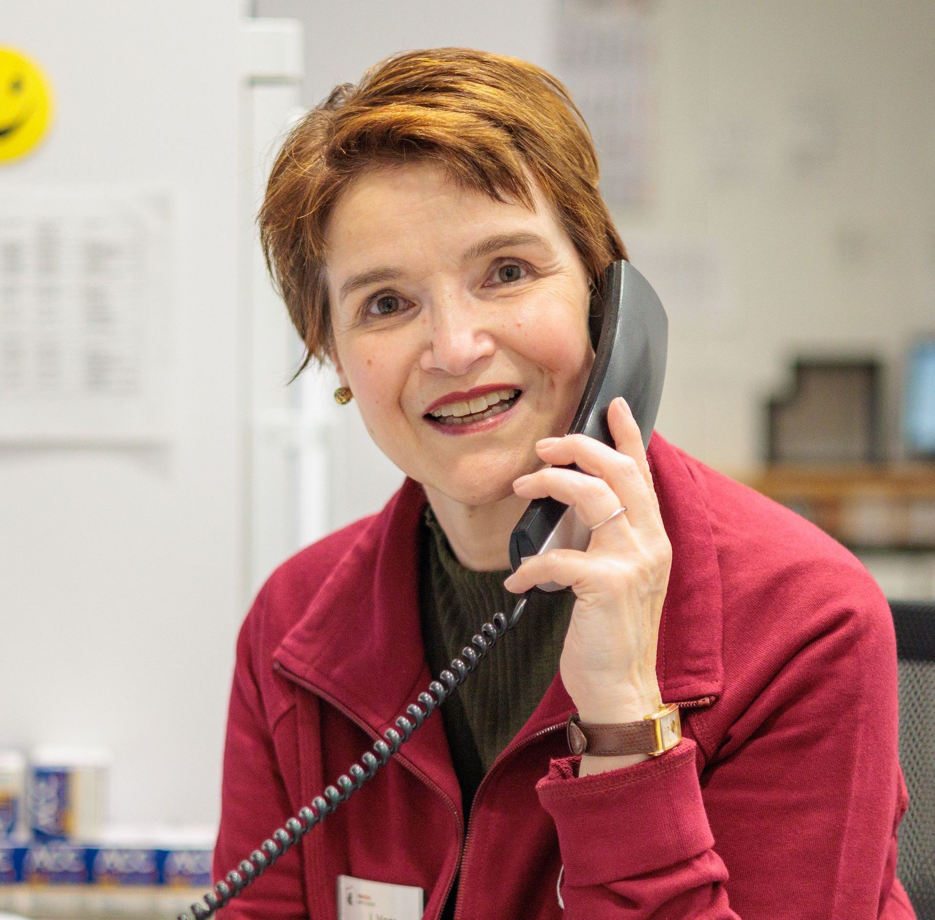 Eine Frau in einer roten Jacke telefoniert.