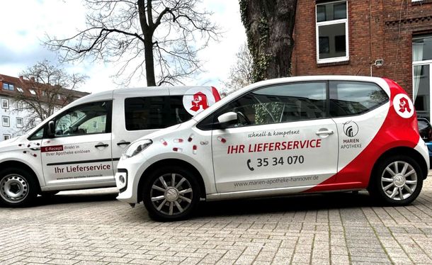 Auf einer Kopfsteinpflasterstraße parken zwei Autos nebeneinander.