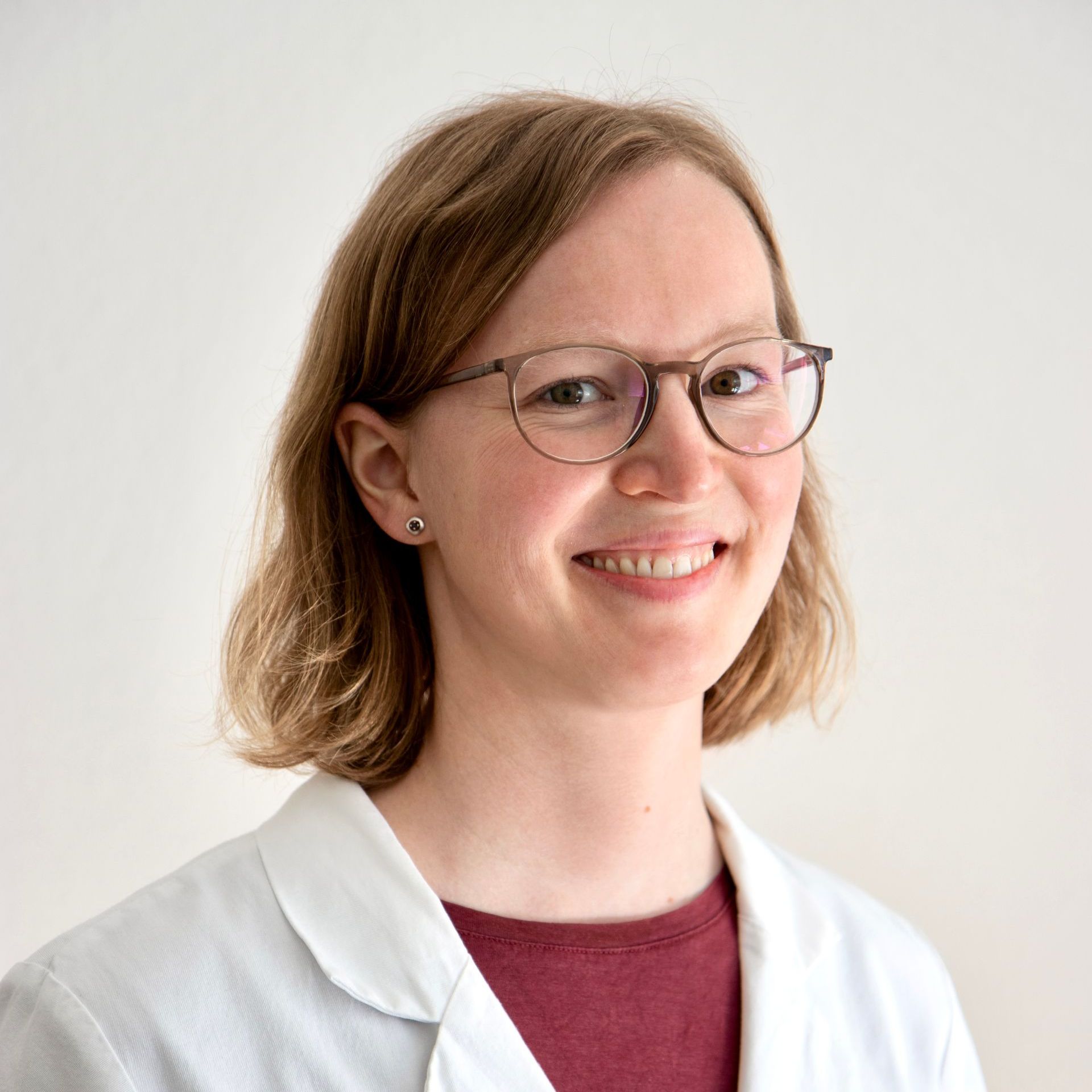 Ein kahlköpfiger Mann mit Bart, Brille und kastanienbraunem Poloshirt