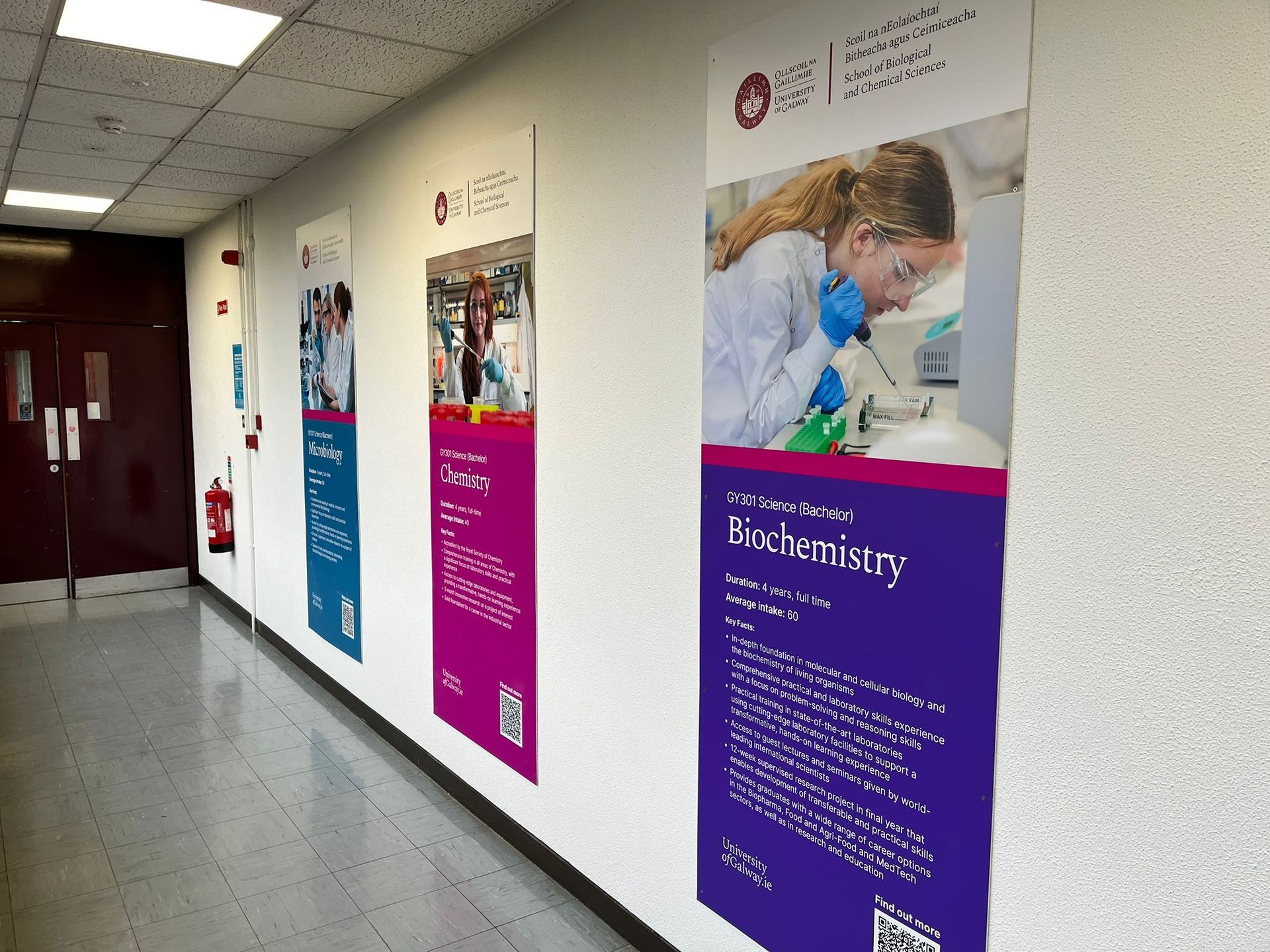 A hallway with posters on the wall including one for biochemistry