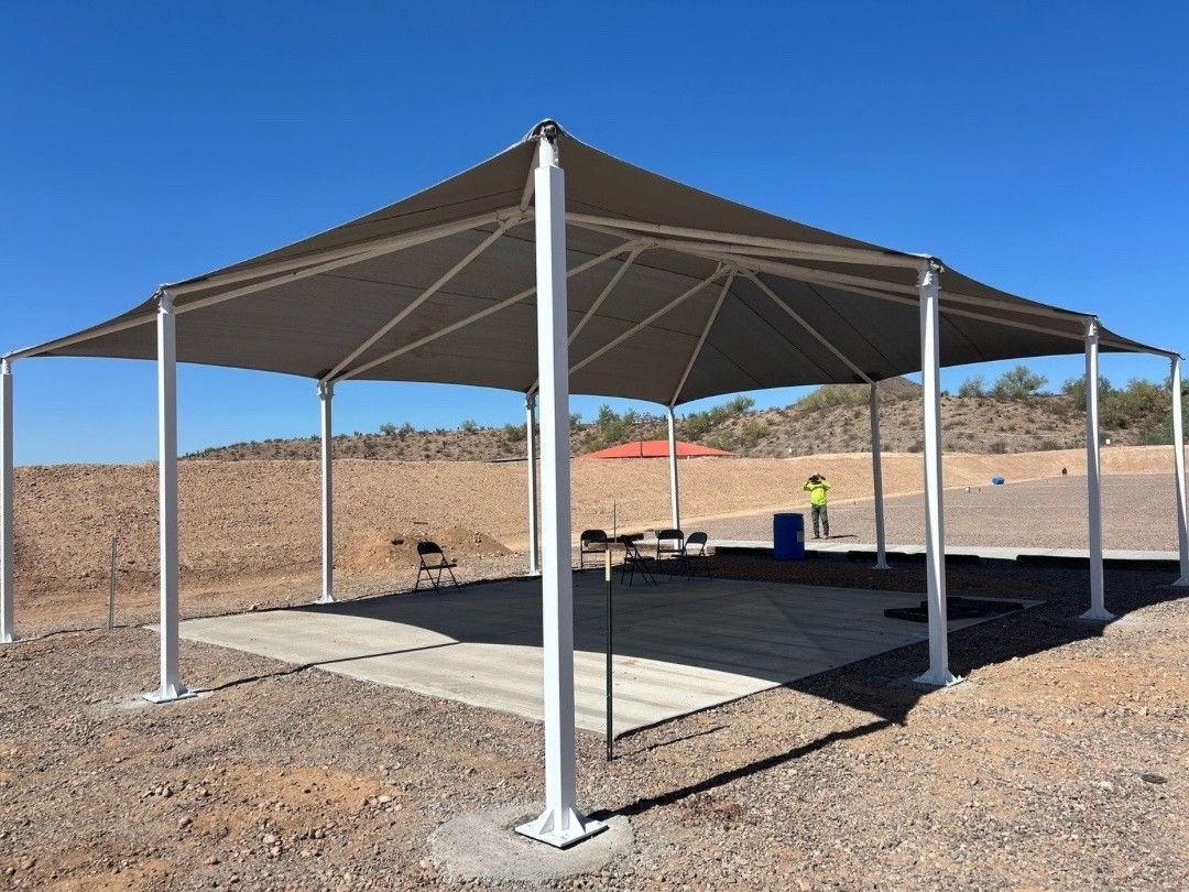 A large tent is sitting in the middle of a dirt field