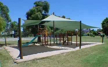 A playground with a green umbrella over it