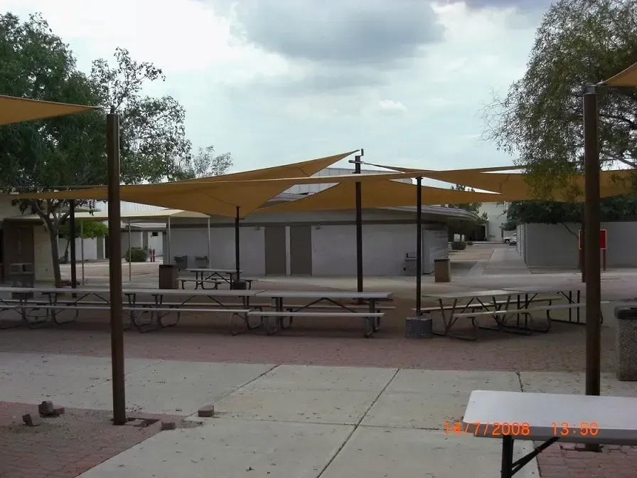 A picnic area with tables and umbrellas on a cloudy day