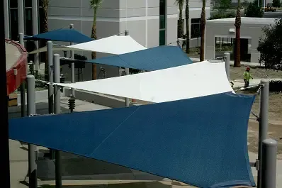 A row of blue and white umbrellas are sitting in front of a building.