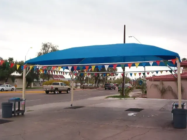 A blue canopy with colorful flags hanging from it