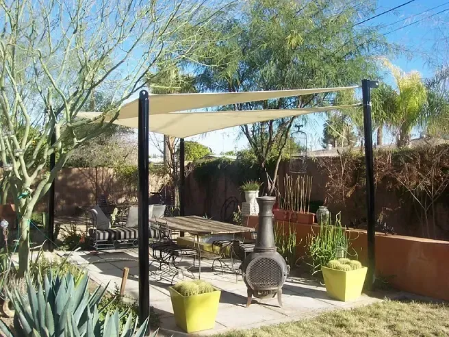 A backyard with a table and chairs under a canopy