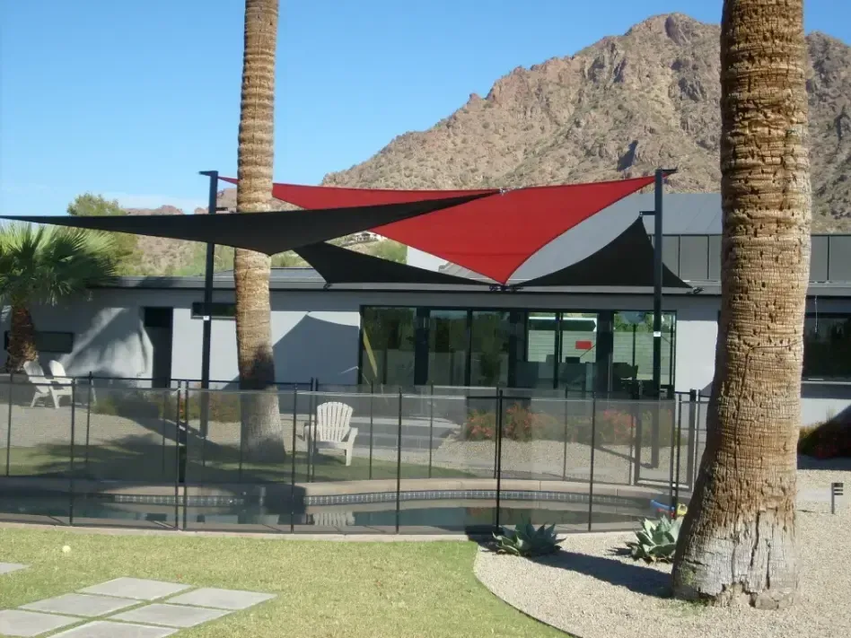 A house with a fence and umbrellas in front of it