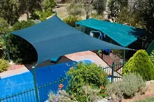 A swimming pool with a green umbrella over it