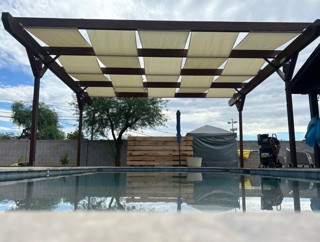 A swimming pool with a pergola over it.