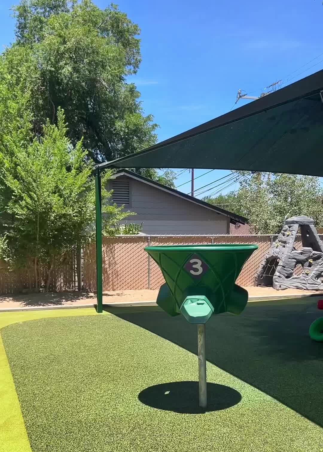 A green object with the number 3 on it is sitting on top of a lush green field.