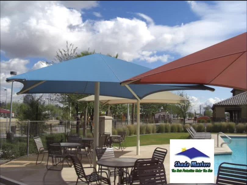 A patio area with tables and chairs under umbrellas and a logo for shade masters
