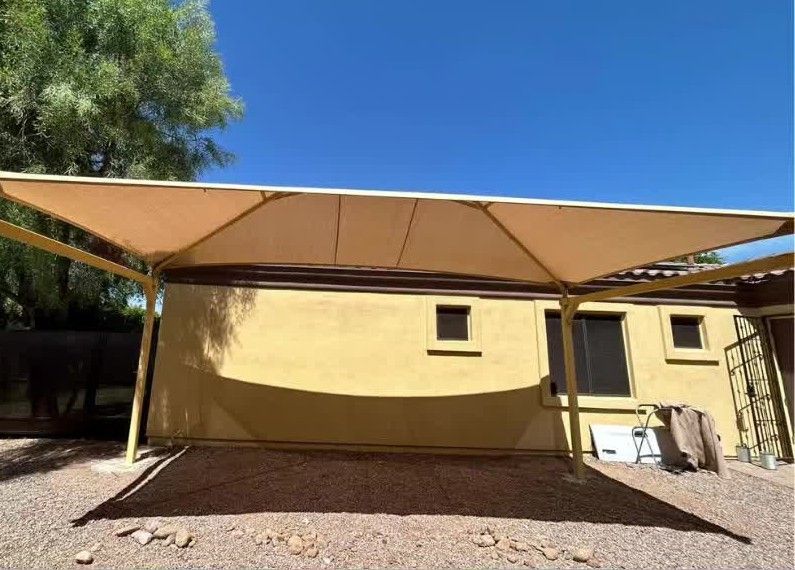 A carport with a canopy over it in front of a house