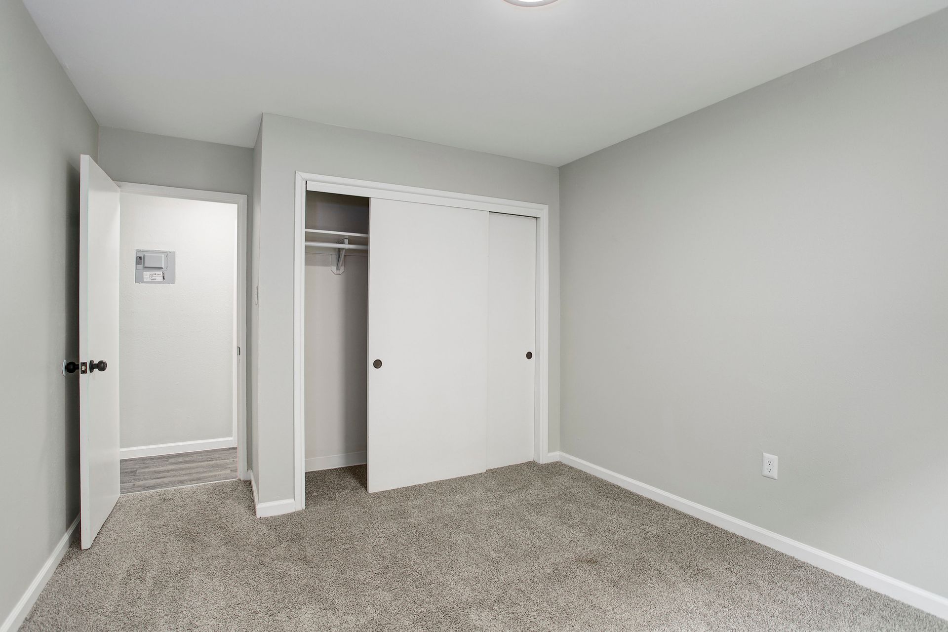 an empty bedroom with a closet and a carpeted floor .