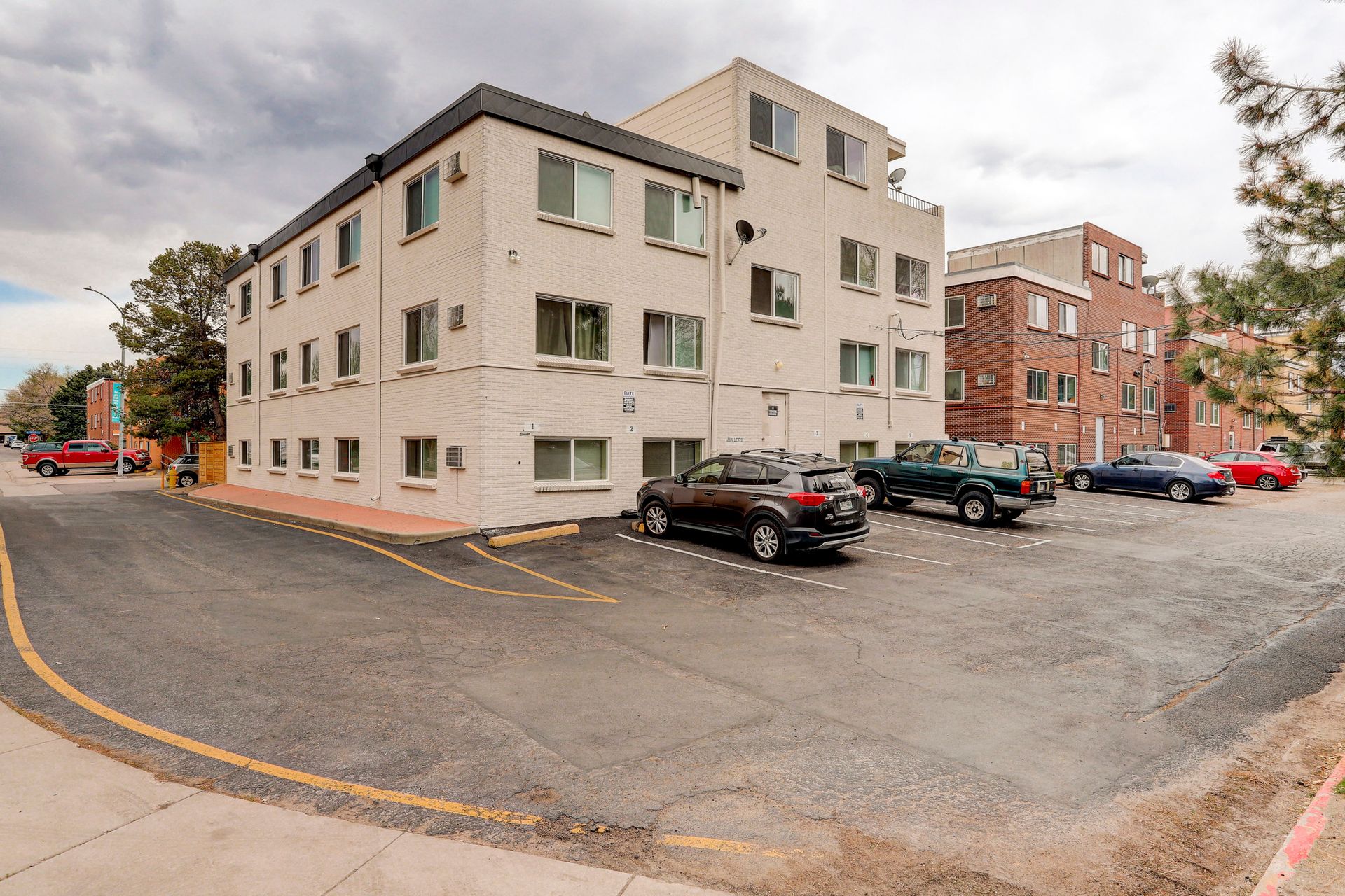 a large white building with cars parked in front of it .