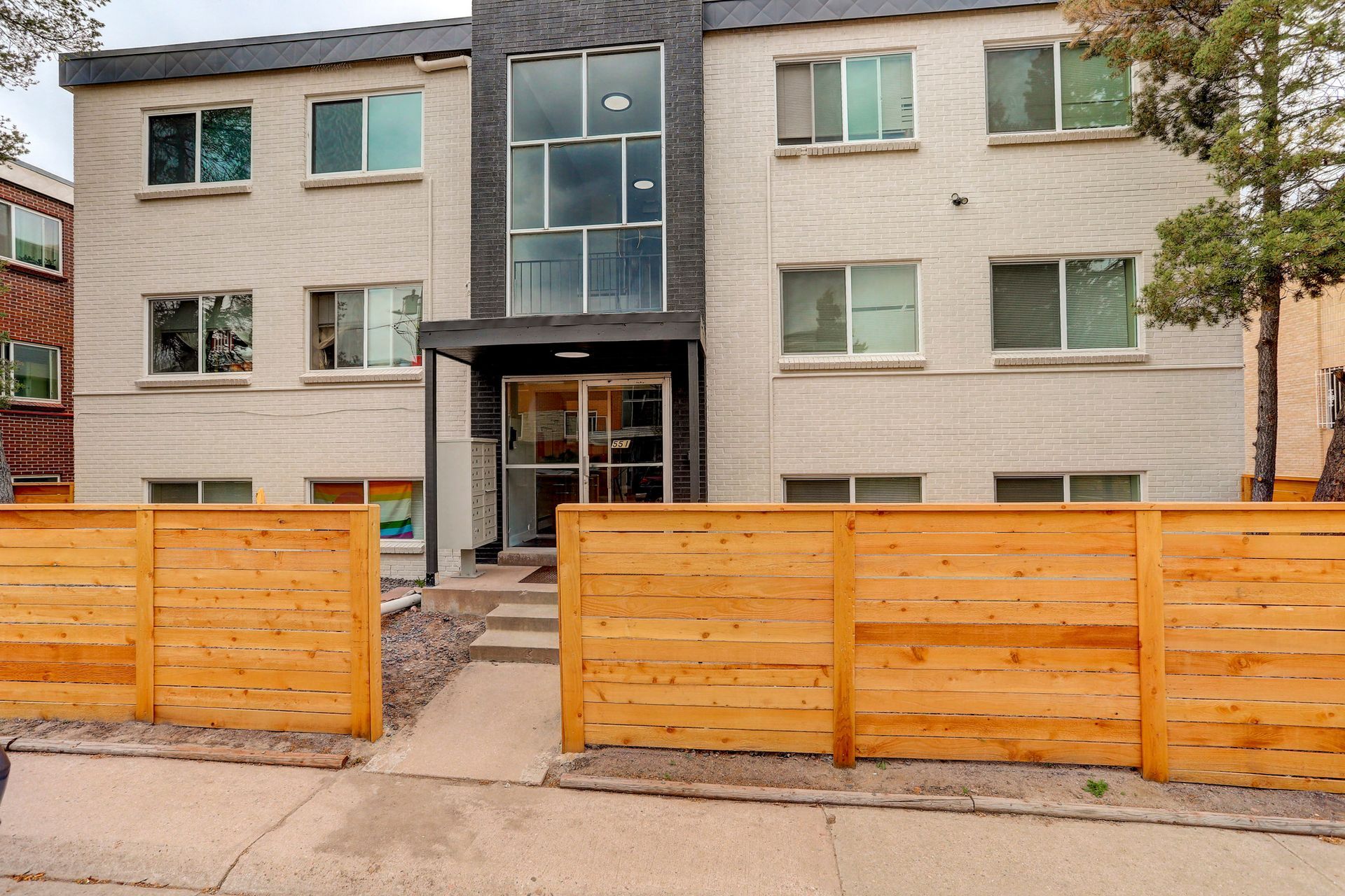 a large apartment building with a wooden fence around it .