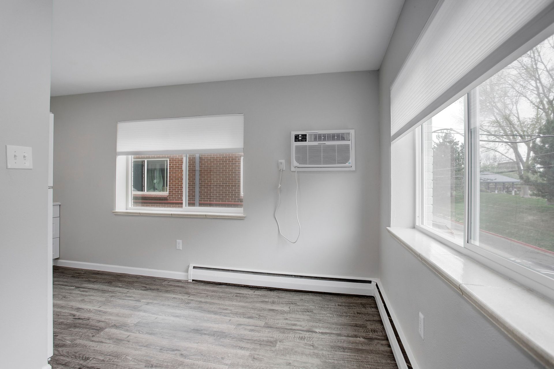 an empty living room with a window and air conditioner .
