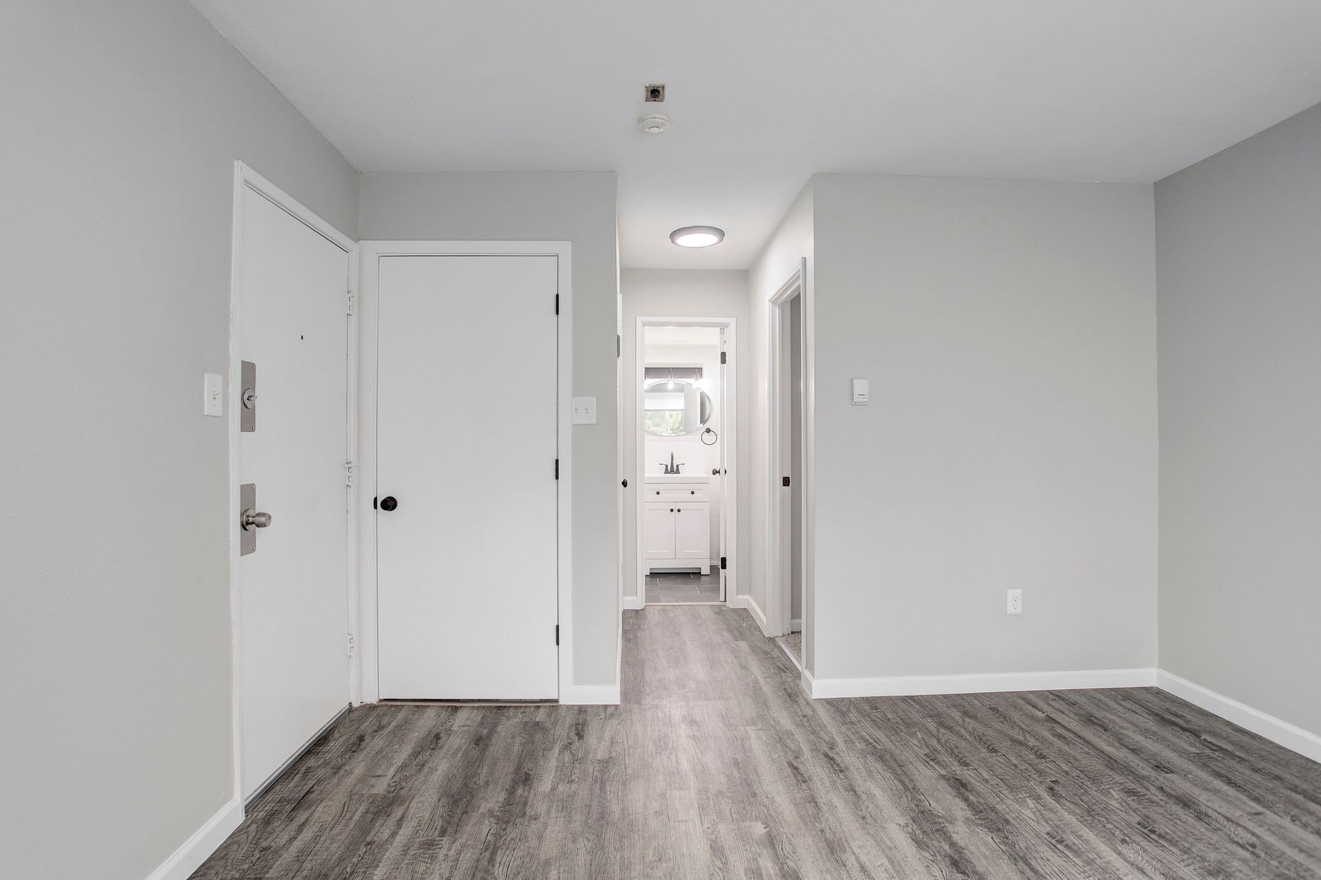 a living room with hardwood floors and white walls .