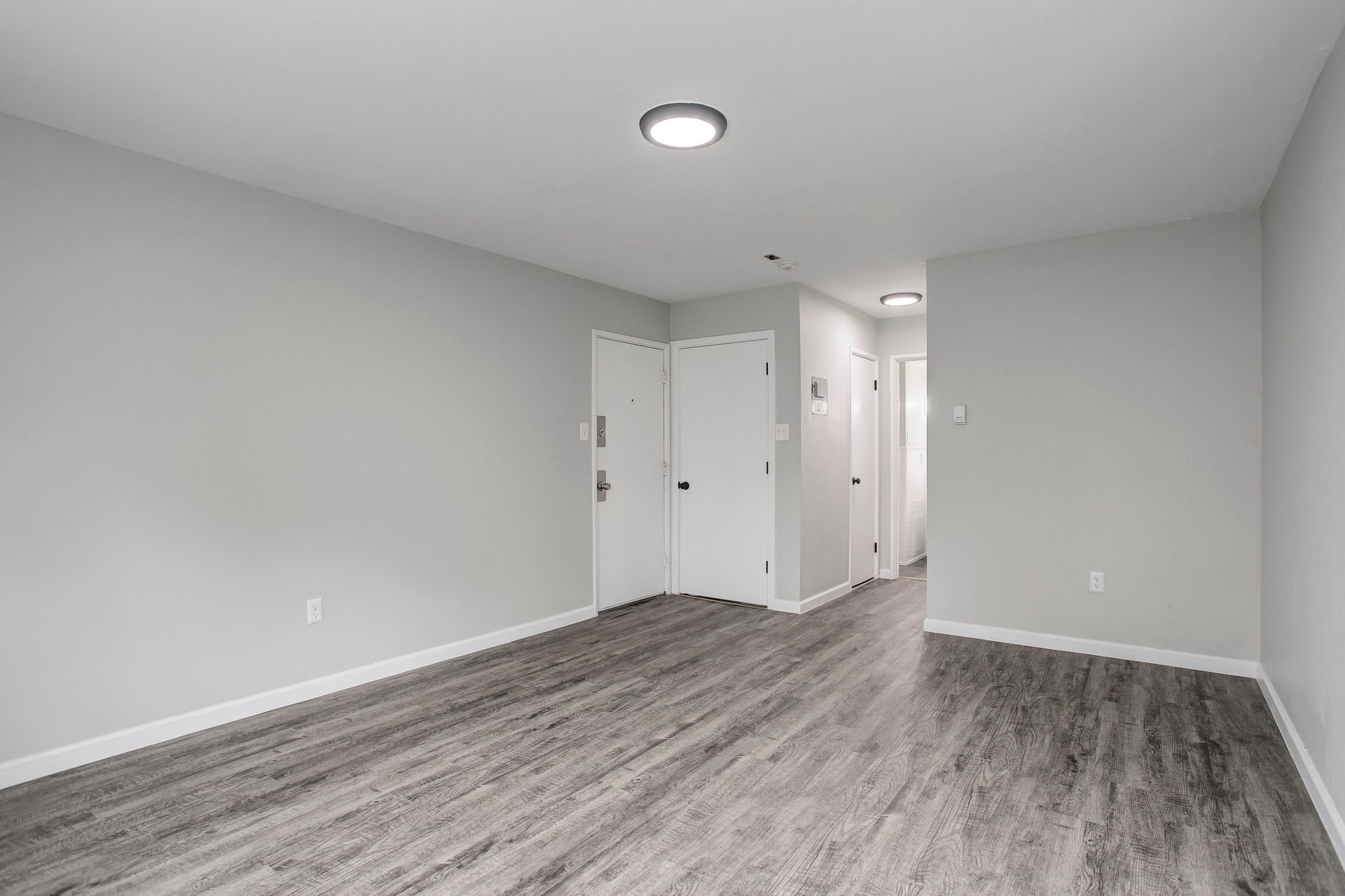 an empty room with hardwood floors and white walls .
