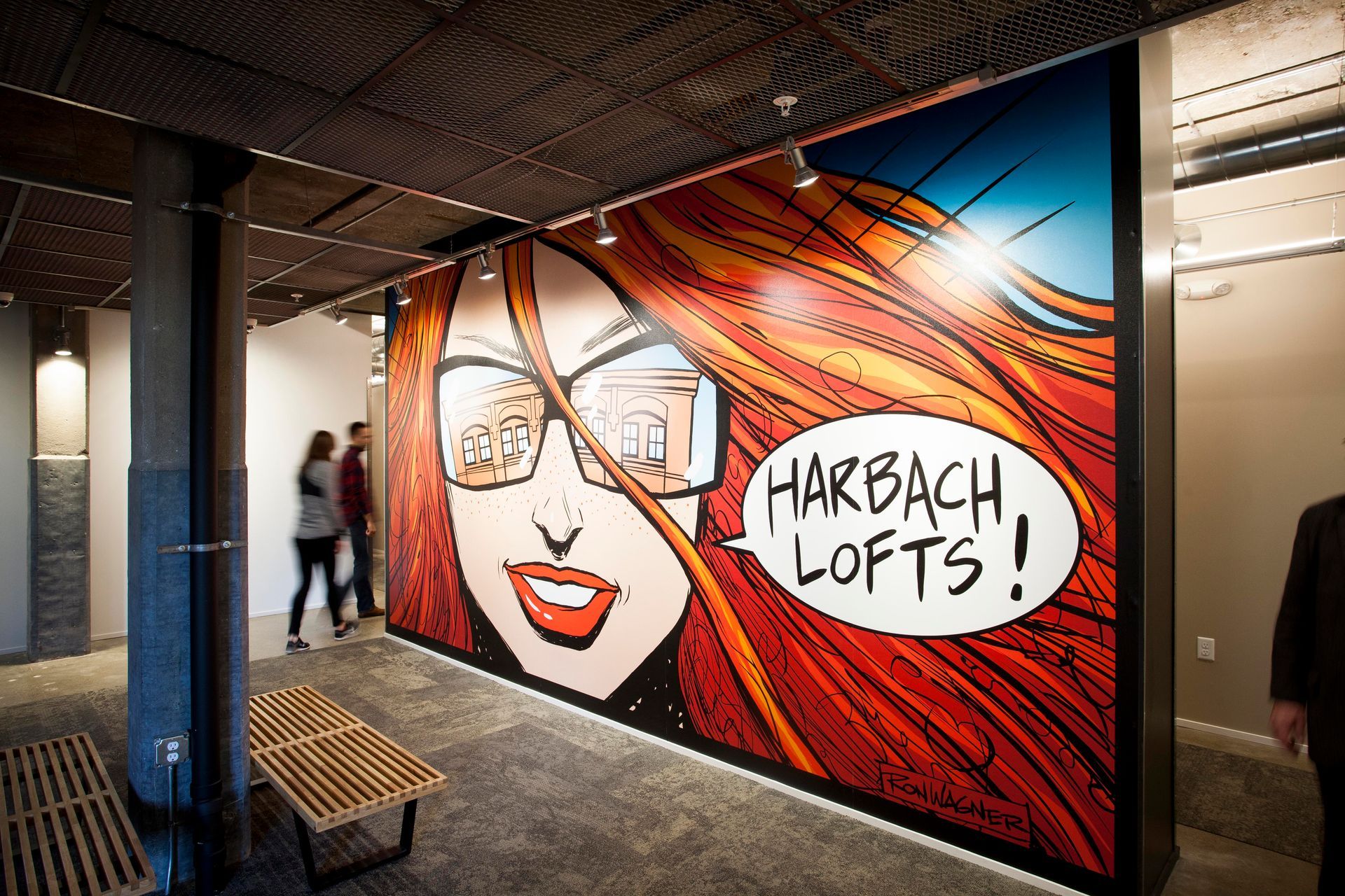a mural of a woman with red hair and glasses says harbach lofts