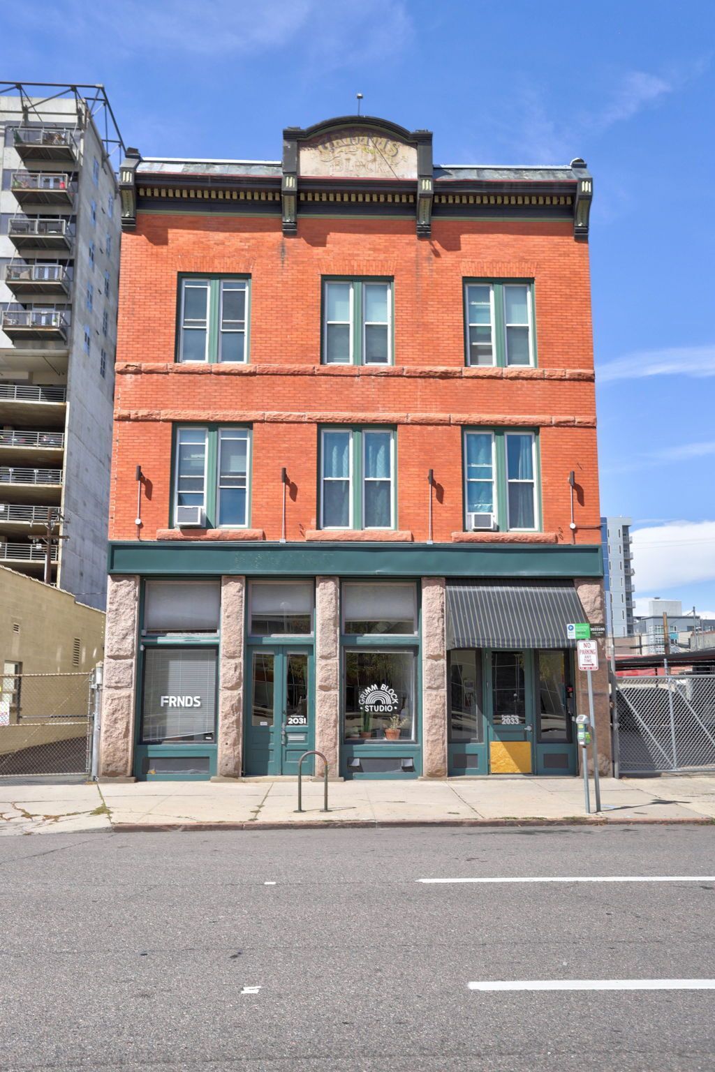 a large red brick building with a green awning