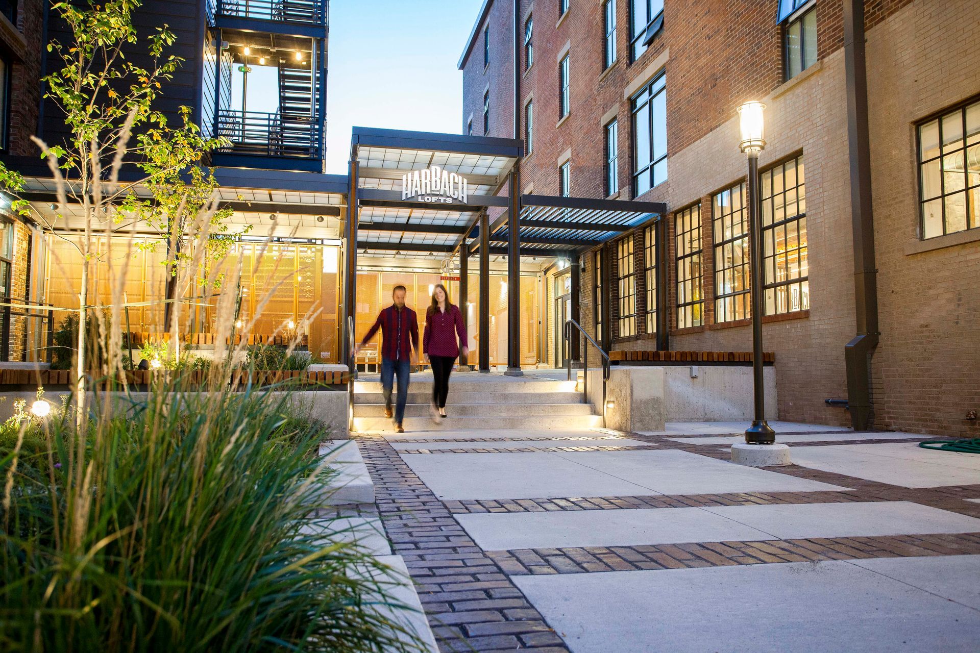 a man and a woman are walking down a sidewalk in front of a building .