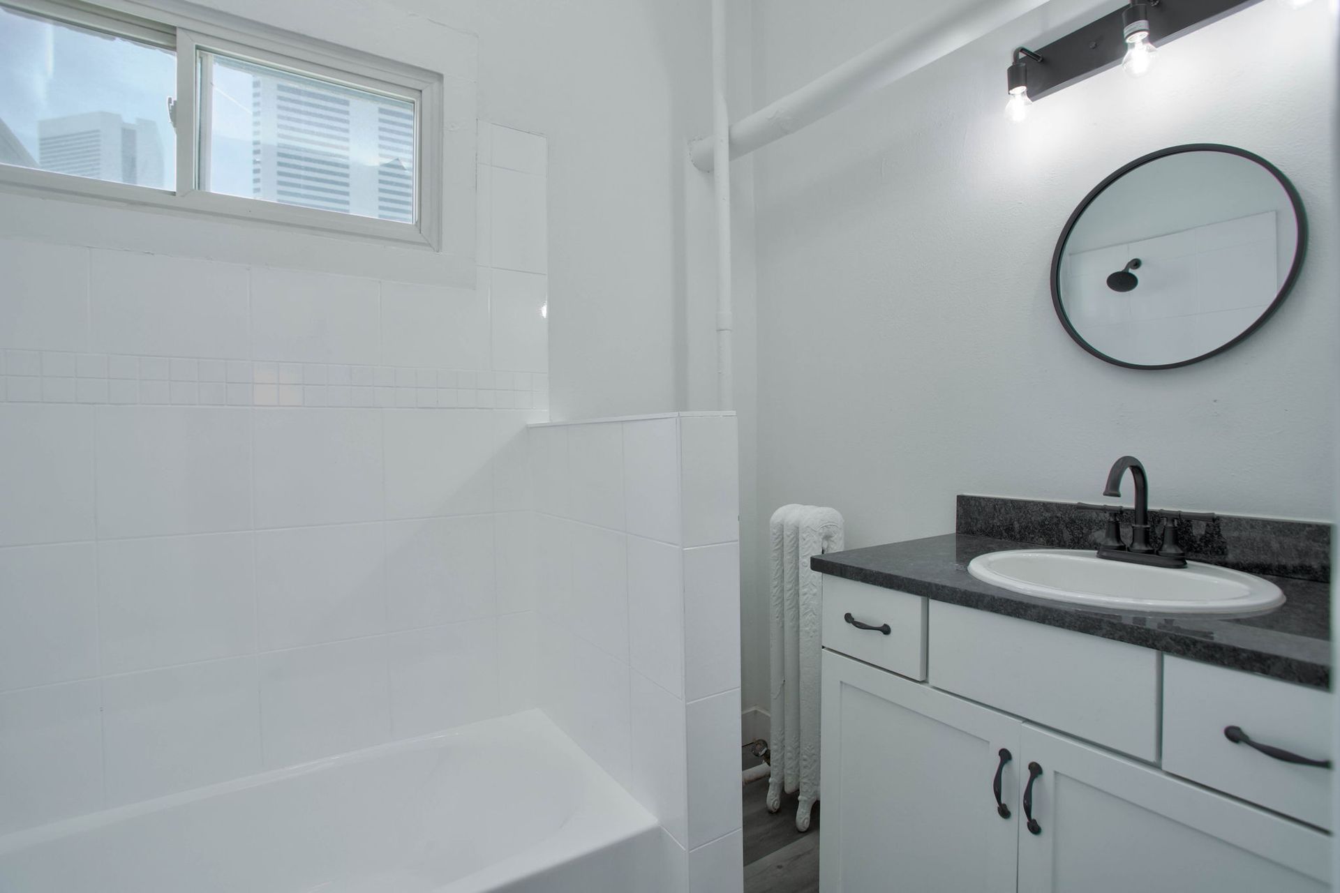 a bathroom with a sink , mirror and bathtub .