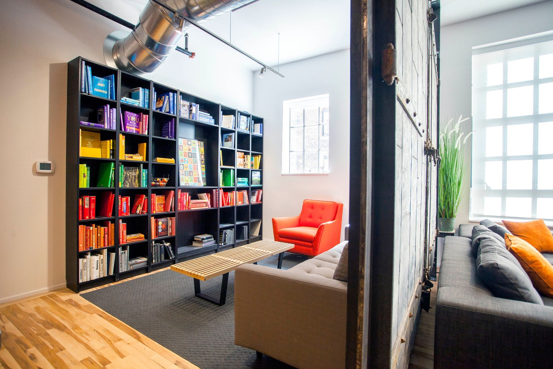 a living room with a couch , chair and bookshelf .
