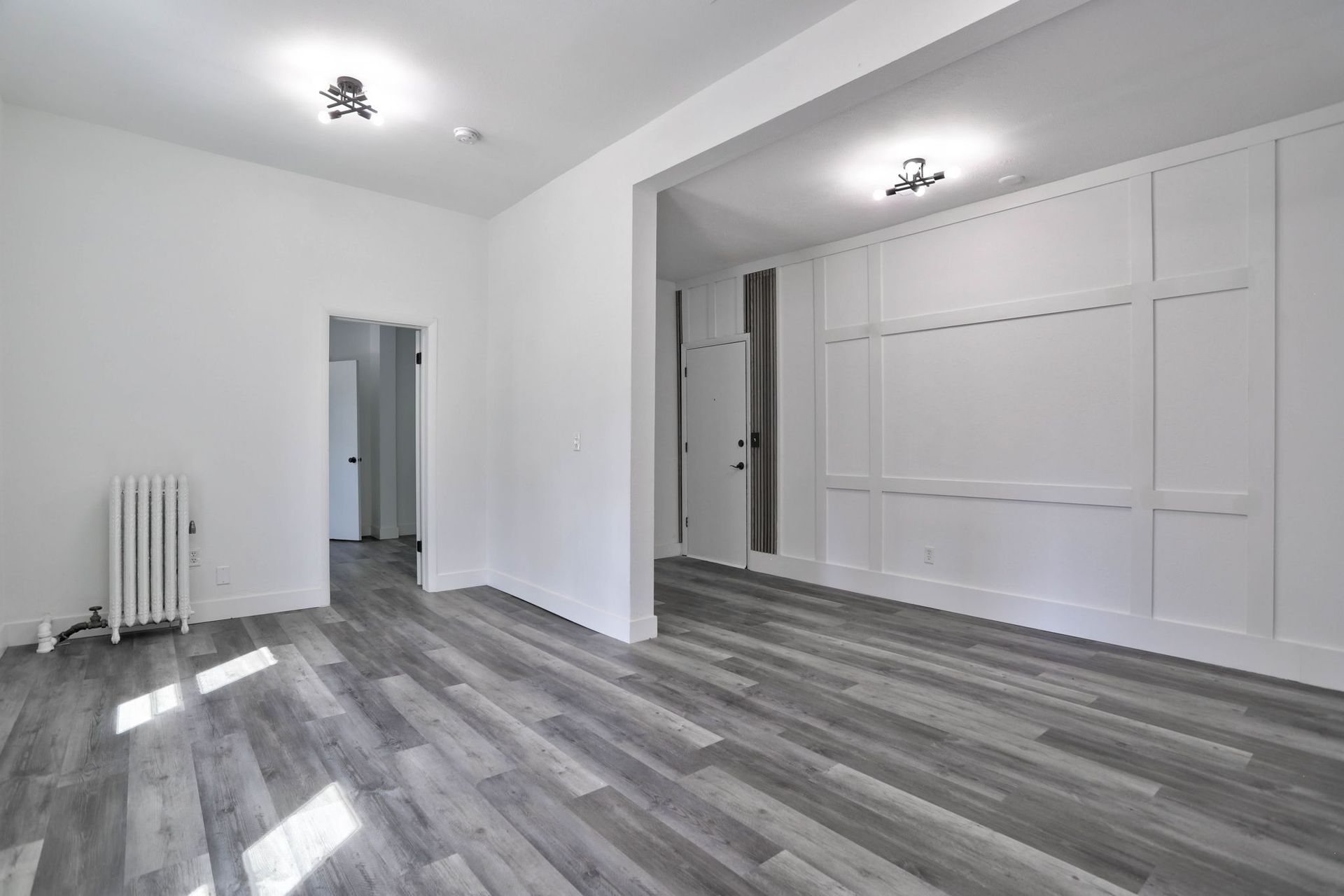 an empty room with a wooden floor and white walls .