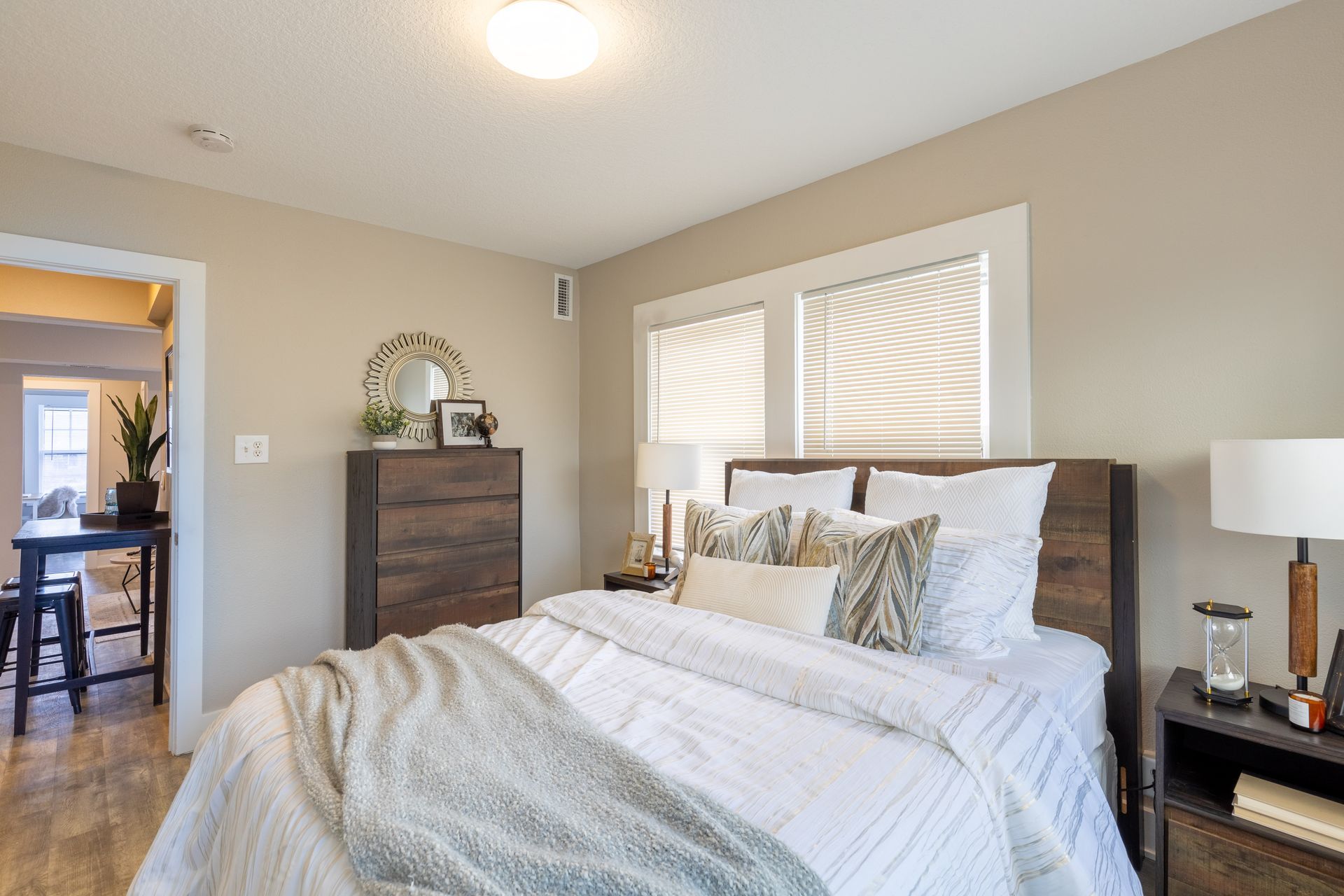 a bedroom with a bed , dresser , nightstand and lamps .