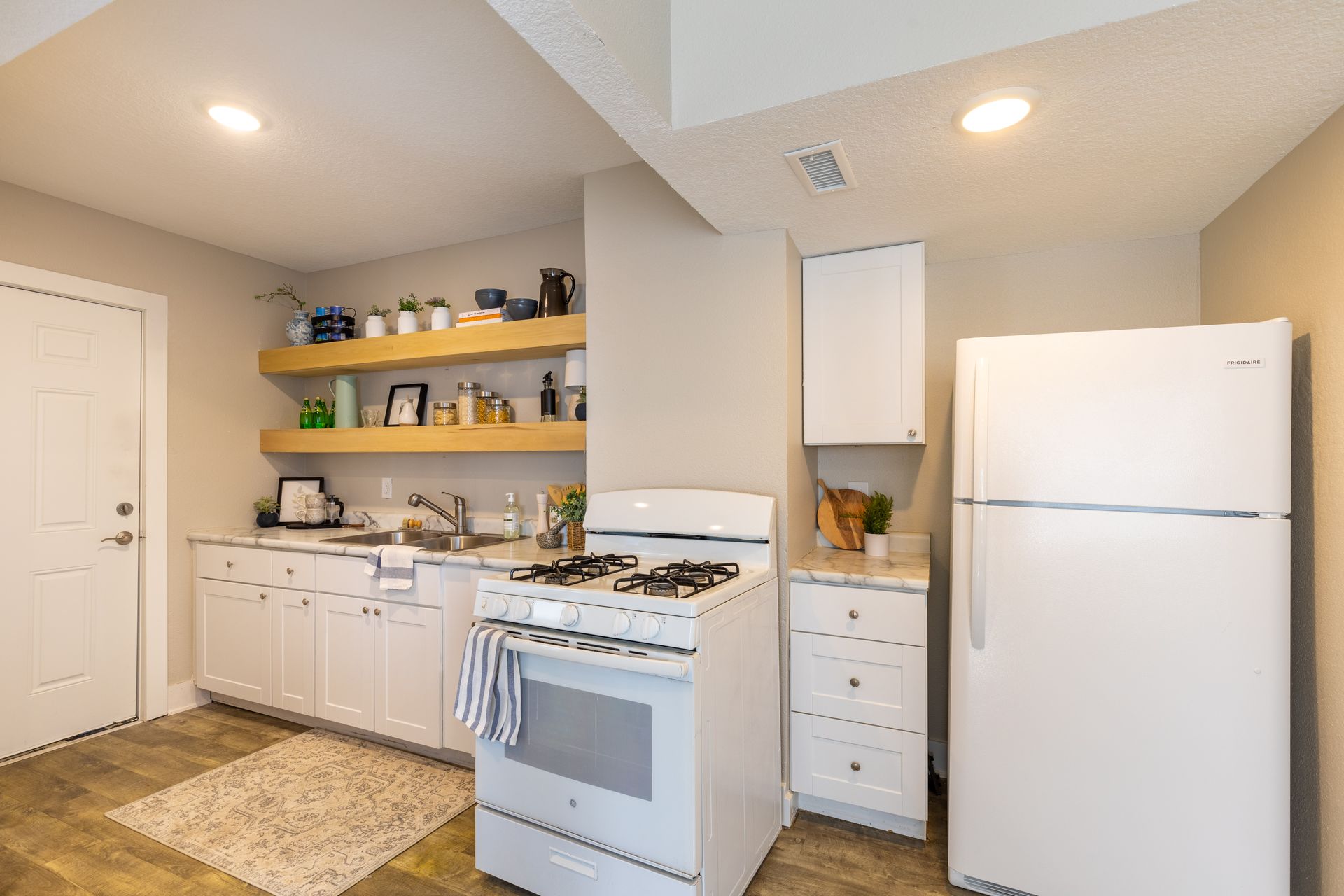 a kitchen with a stove , refrigerator , and sink .