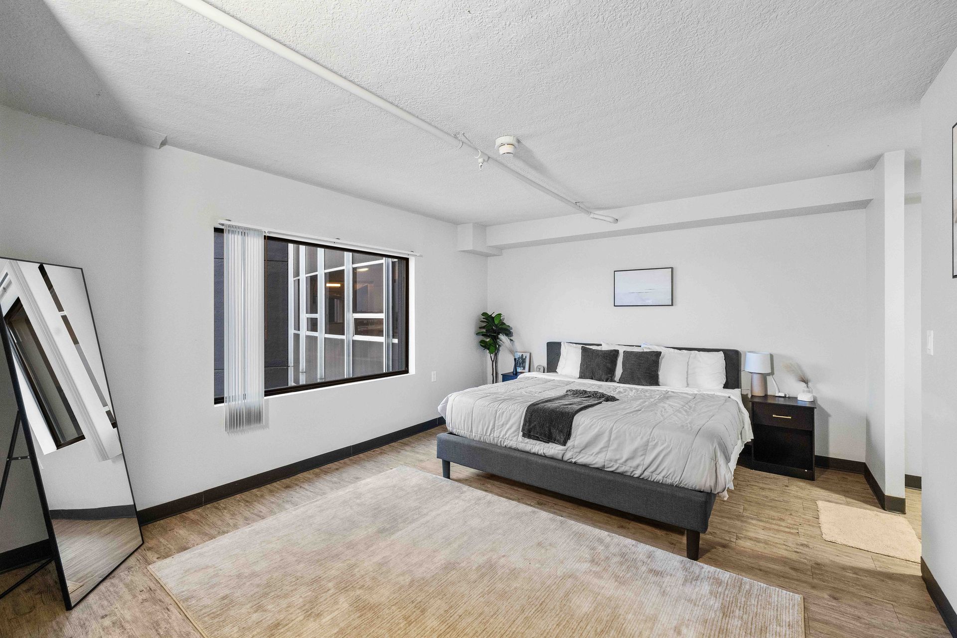 a bedroom with a large bed and a mirror .