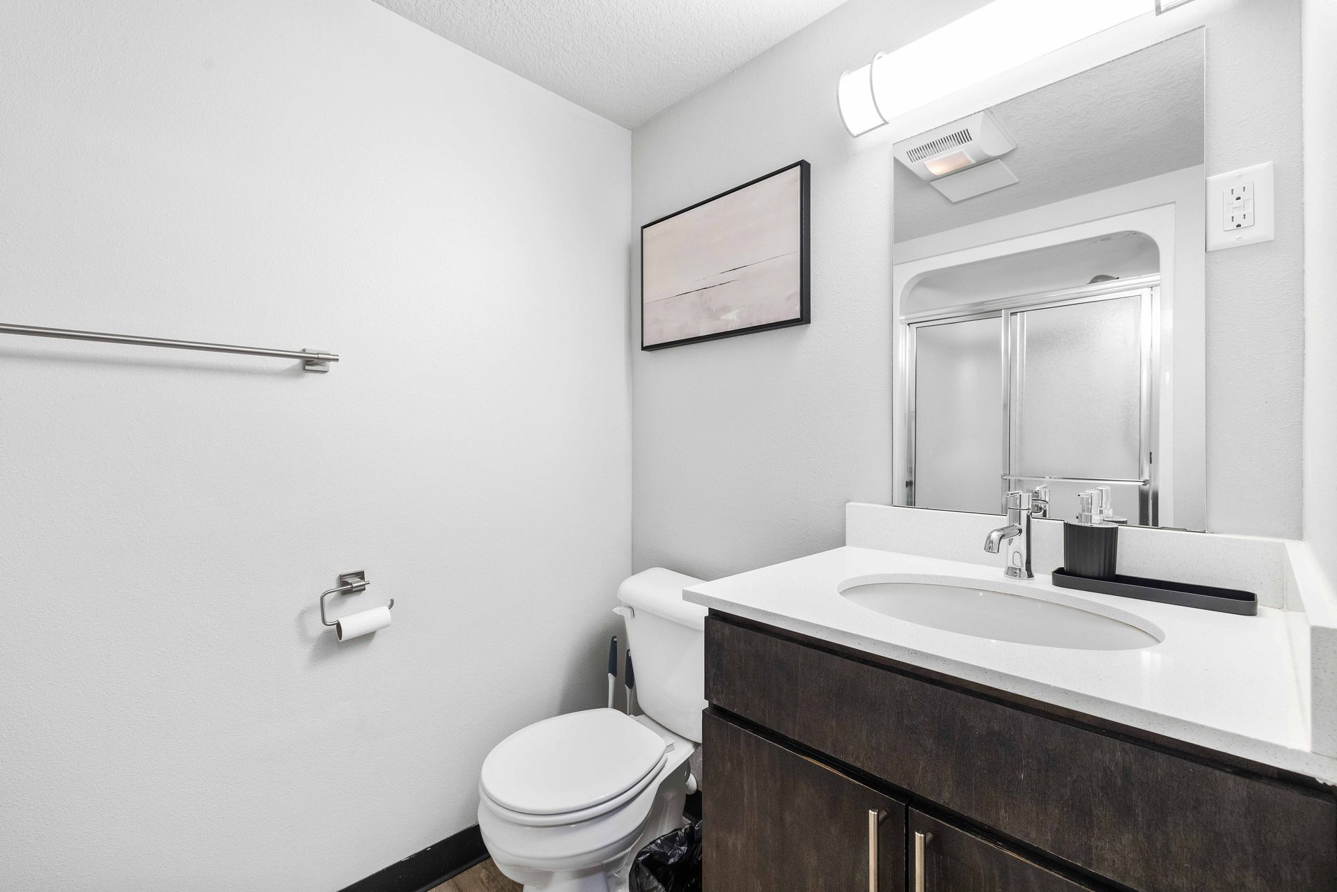 a bathroom with a toilet , sink and mirror .