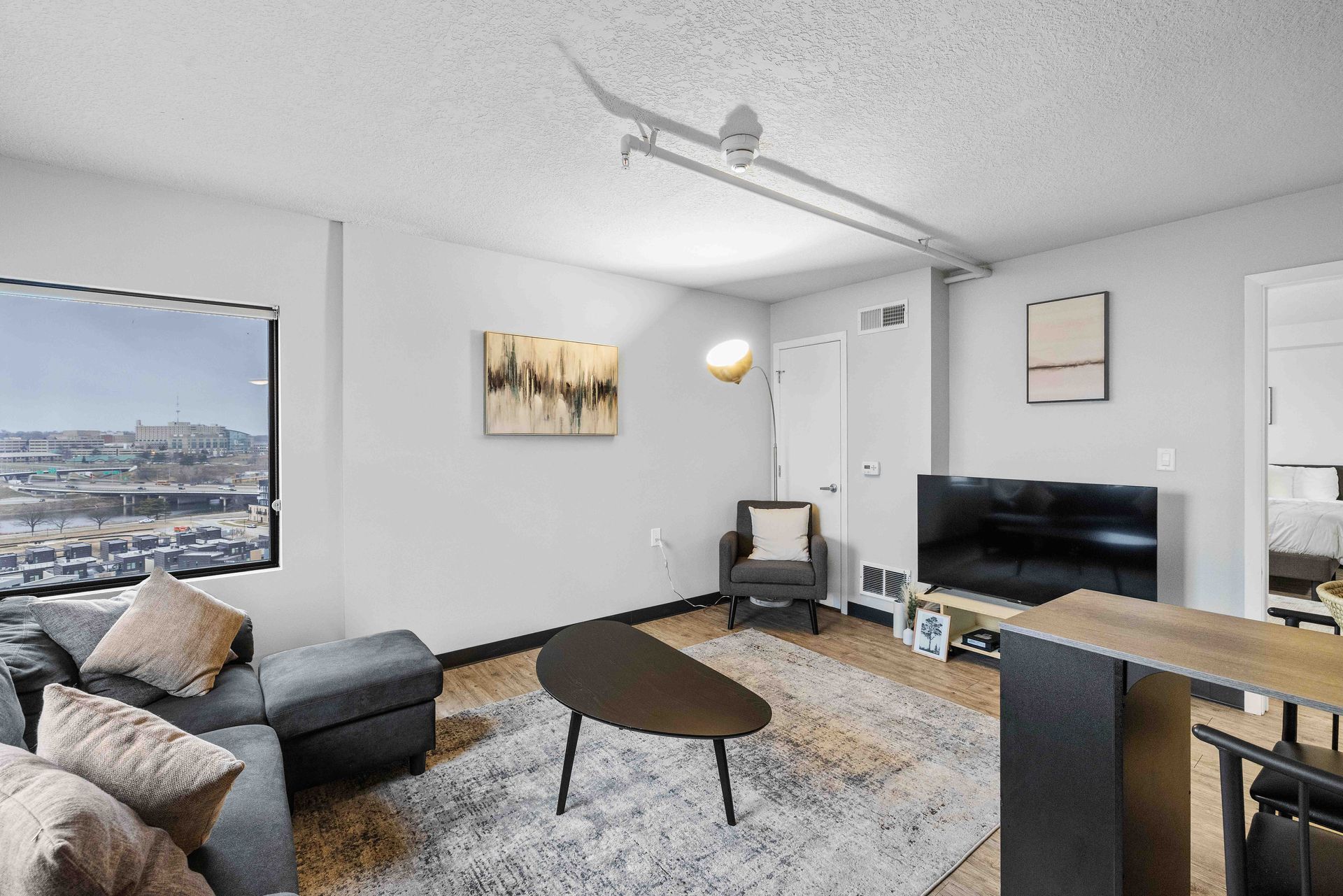 a living room with a couch , chair , coffee table and television .