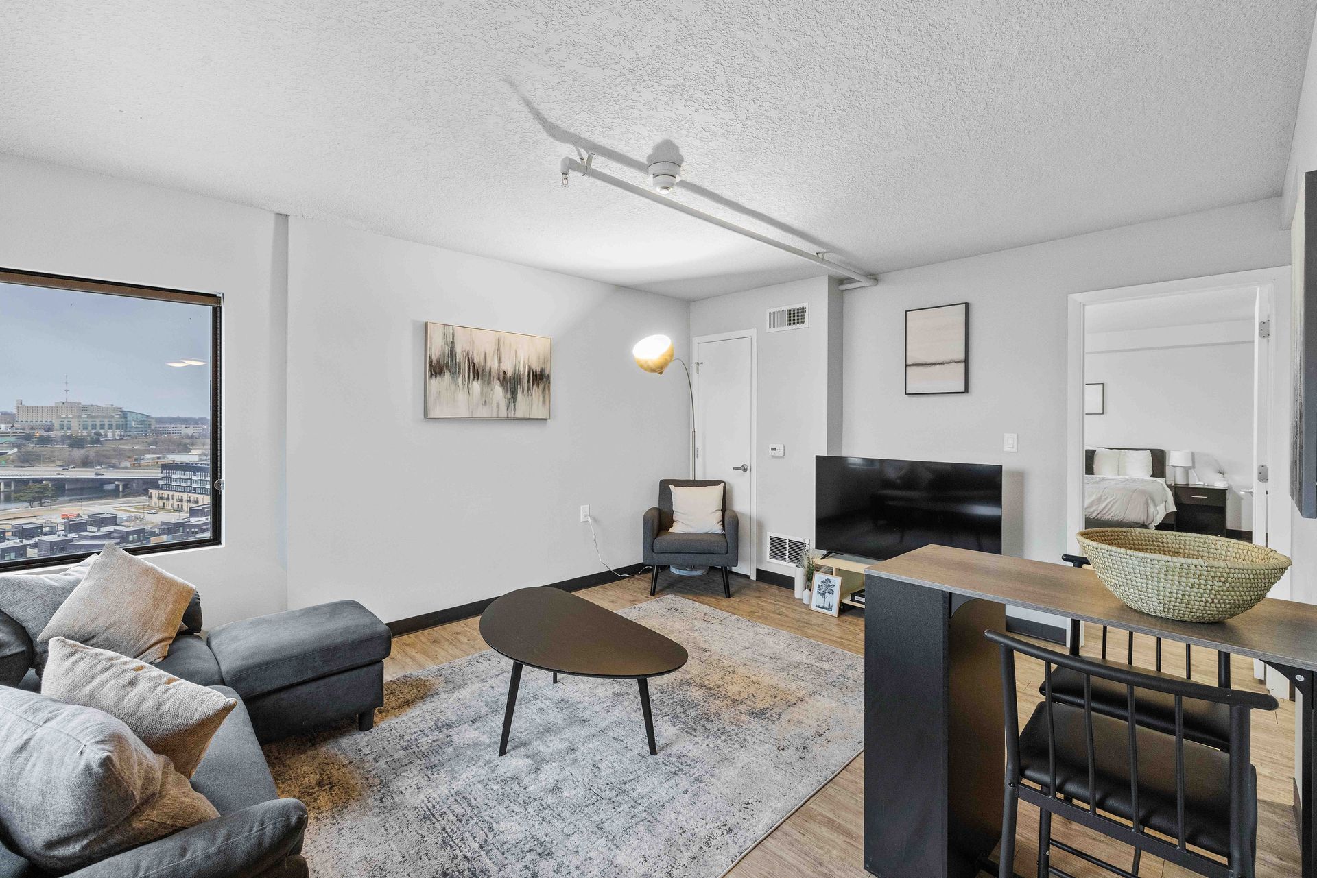 a living room with a couch , chair , coffee table and television .