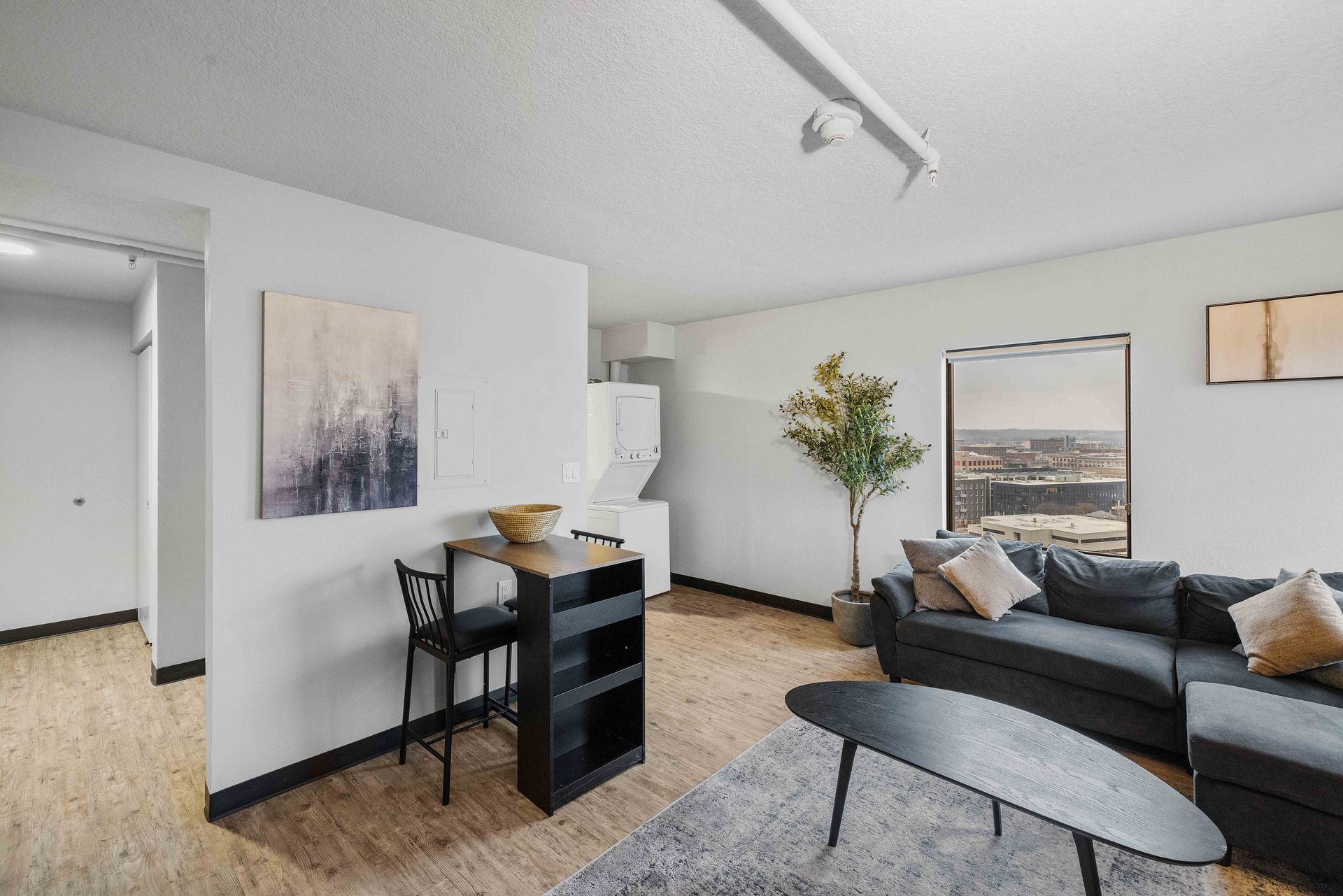 a living room with a couch , table , chairs and a painting on the wall .