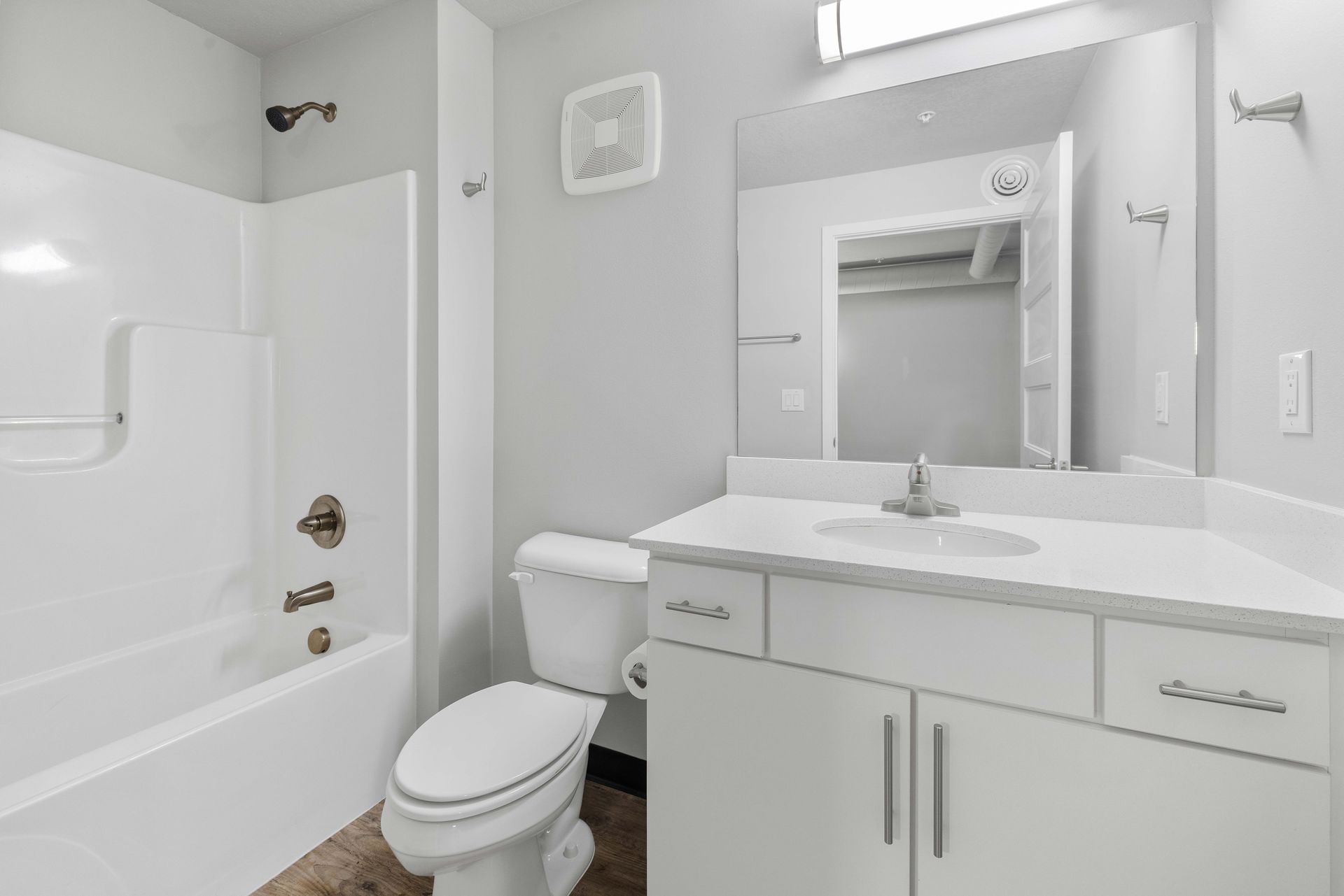 a bathroom with a toilet , sink , bathtub and mirror .