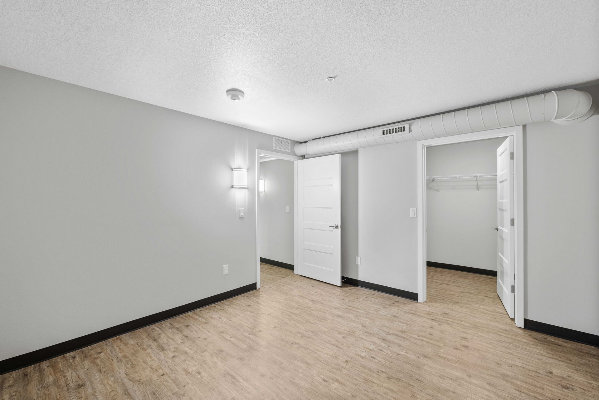 a hallway in a house with hardwood floors and white walls .