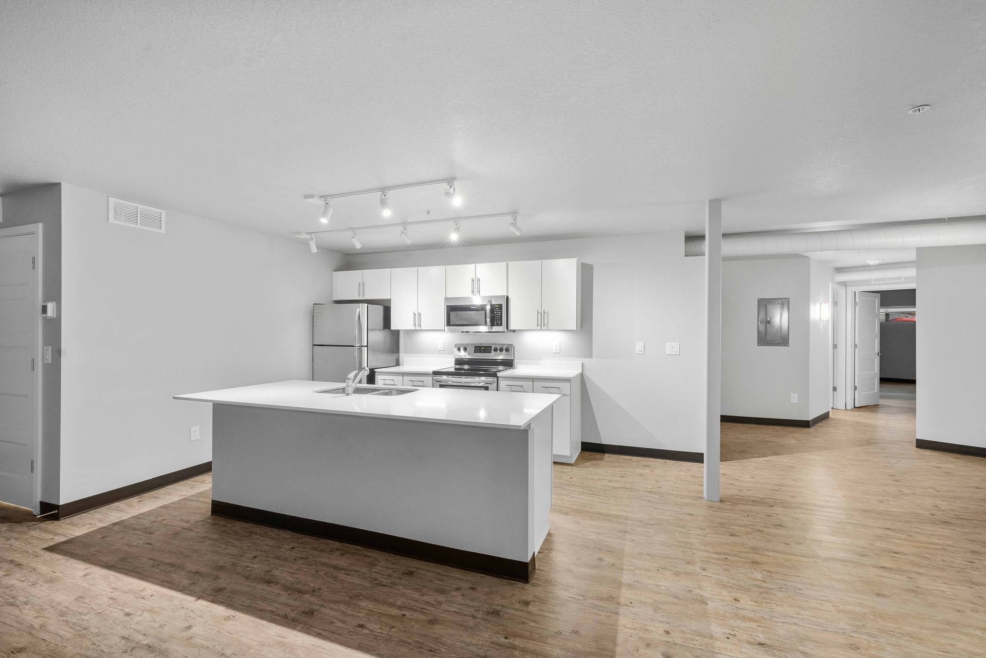 an empty kitchen with a large island and two sinks .