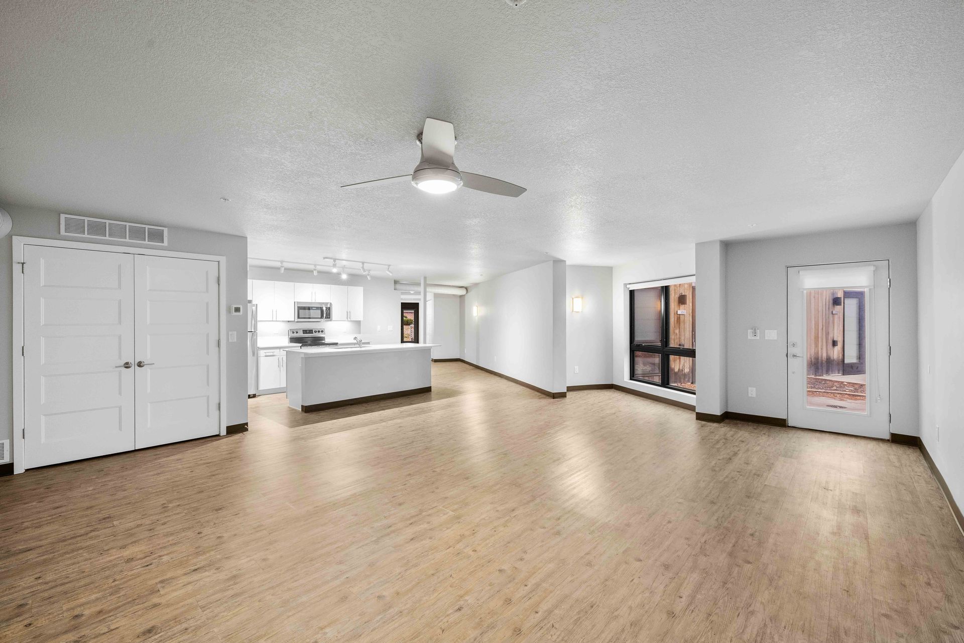 a kitchen with white cabinets , stainless steel appliances , and a large island .