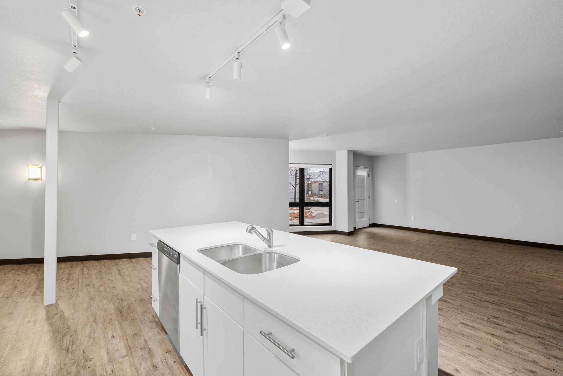 a kitchen with white cabinets , stainless steel appliances and a large island .