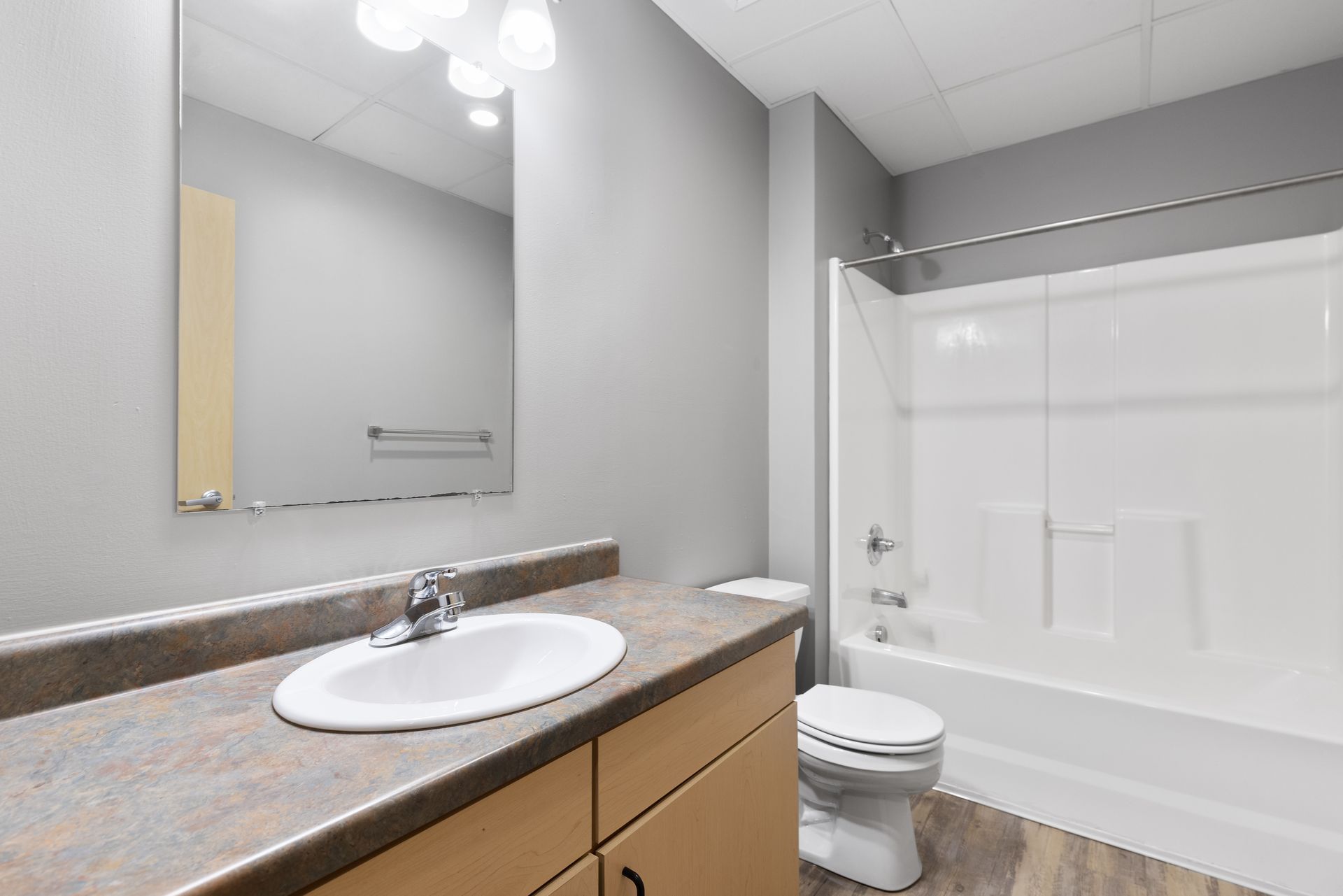 a bathroom with a sink , toilet , bathtub and mirror .