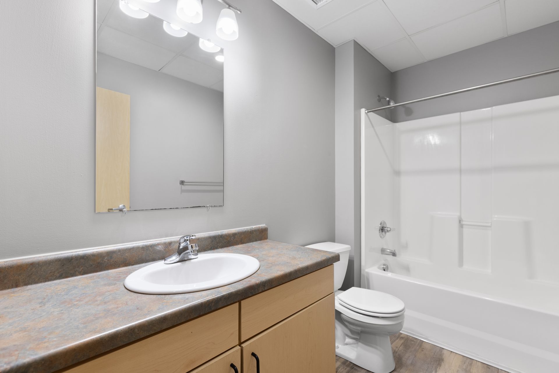 a bathroom with a sink , toilet , tub and mirror .