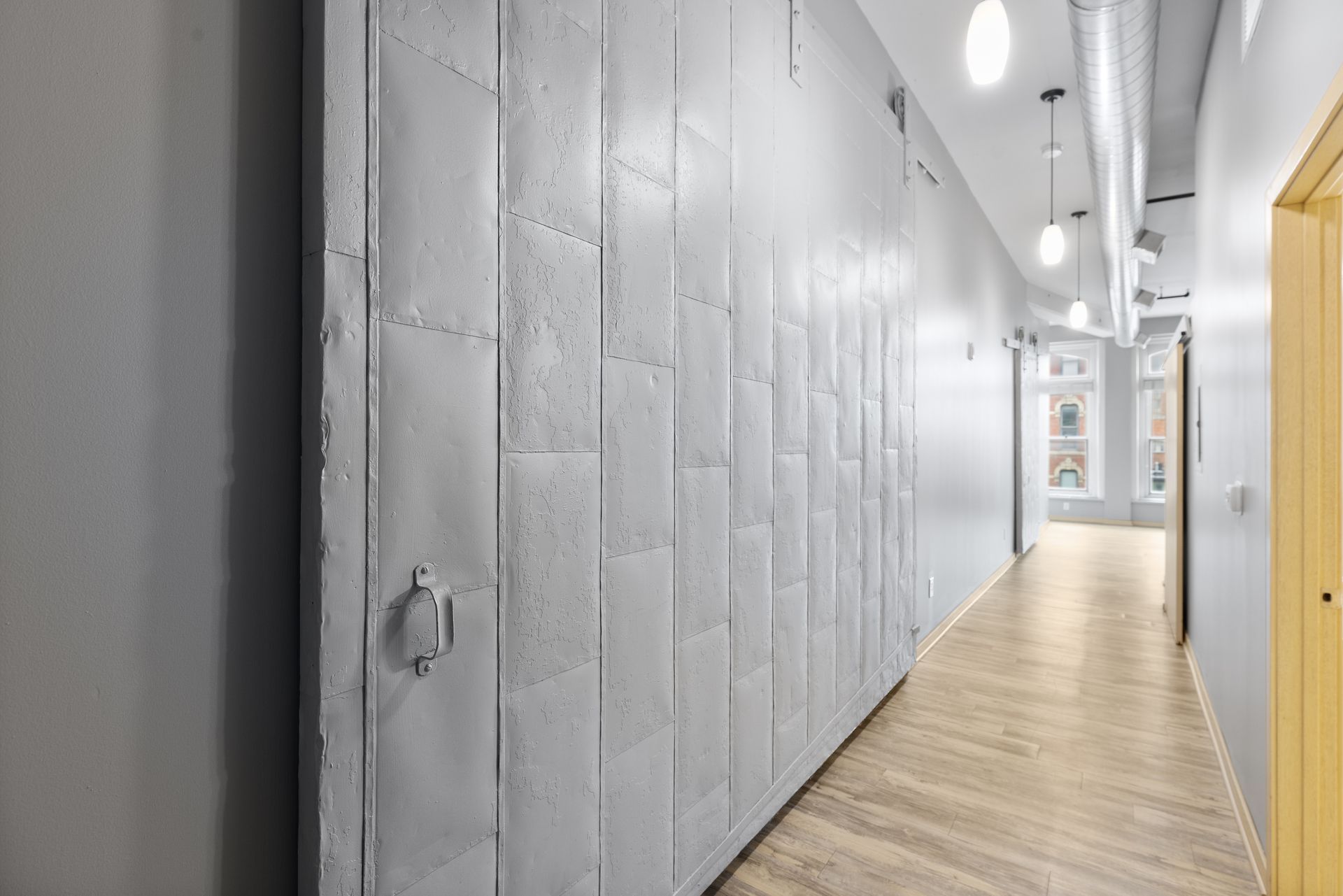 a long hallway with white walls and a wooden floor .