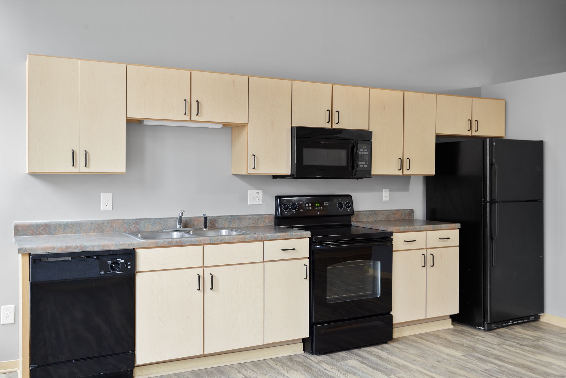 a kitchen with white cabinets and black appliances