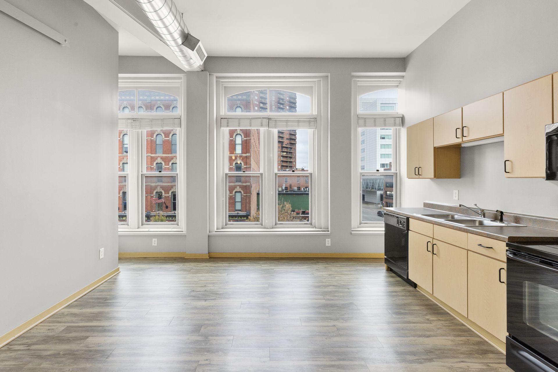 an empty kitchen with a lot of windows and cabinets