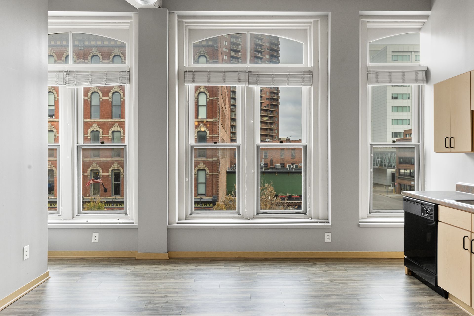 an empty apartment with a lot of windows and a kitchen .