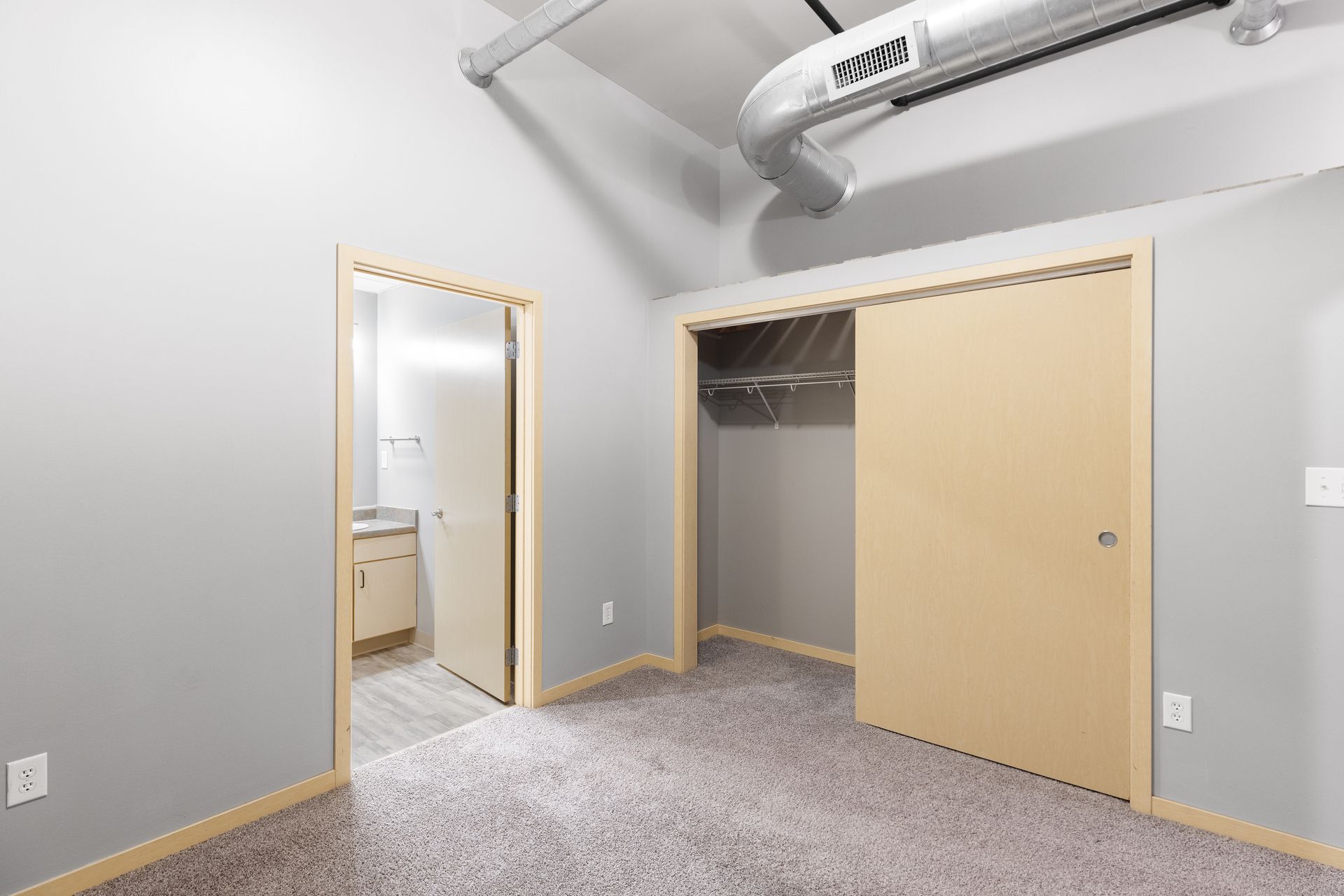 an empty bedroom with a closet and a bathroom .