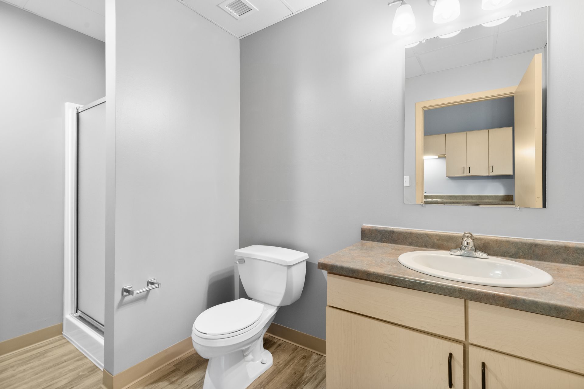 a bathroom with a toilet , sink and mirror .