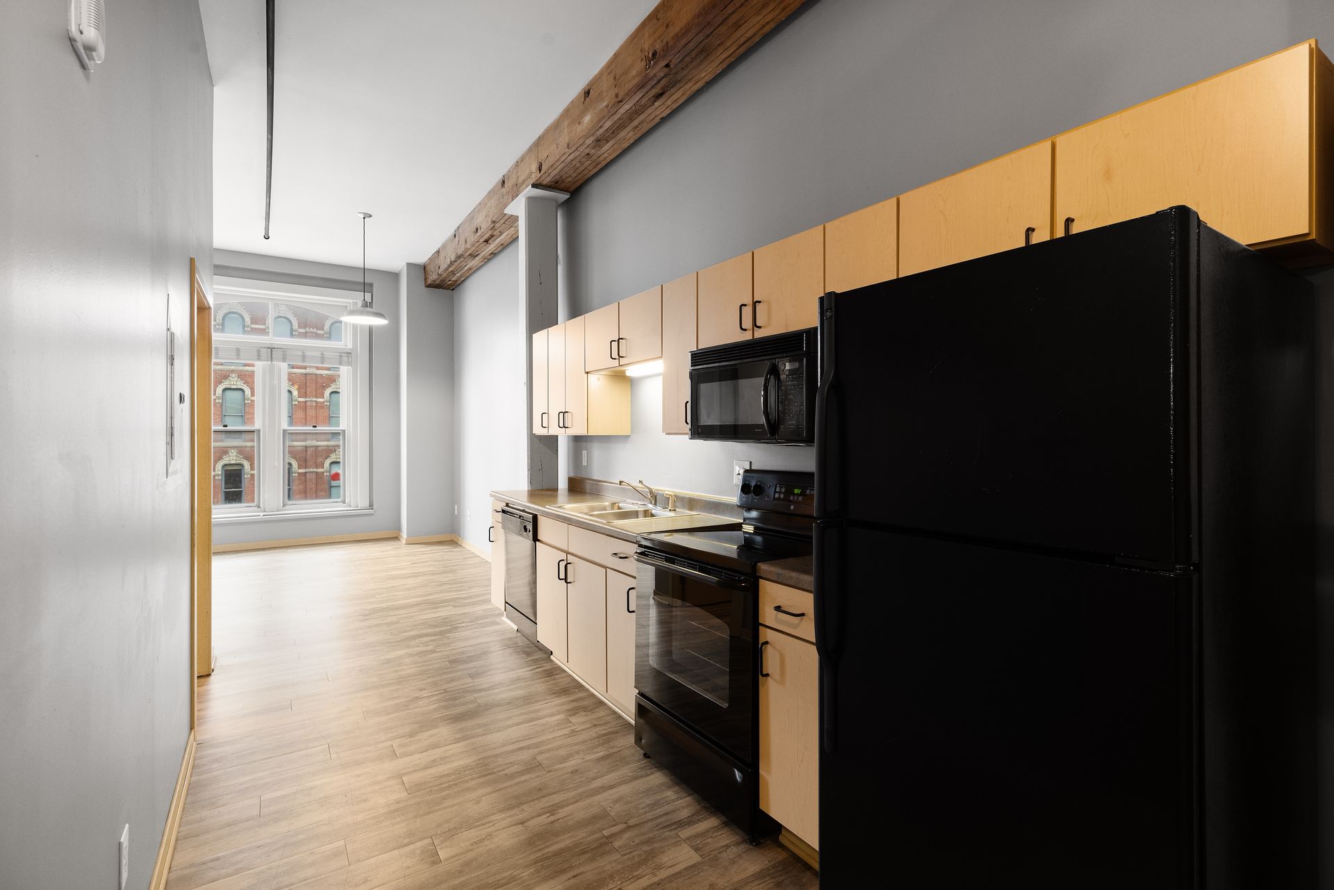a kitchen with a black refrigerator , stove , microwave and sink .